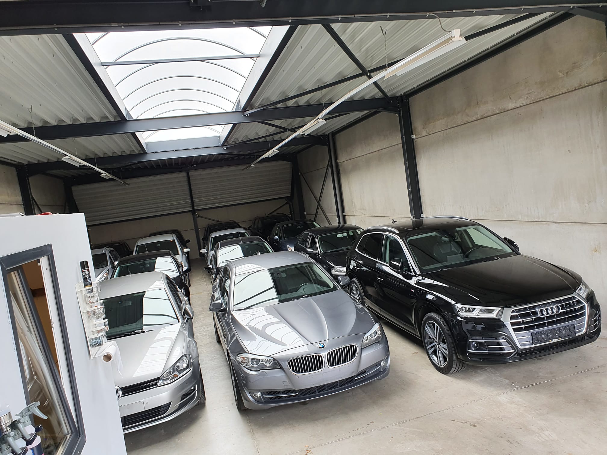 Audi Q5, BMW 5-Series and other cars under the skylight of the R1 Cars garage